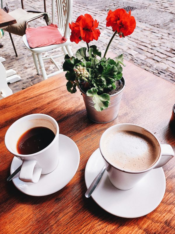 Image of two coffee cups on a table at outside cafe - The Fave Real