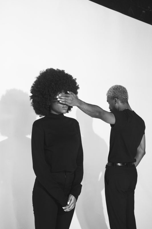 Black and white image of a man putting his hand over a woman's eyes - Fave Real